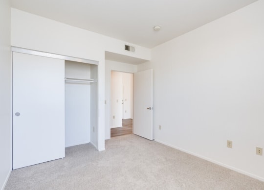 a bedroom with white walls and carpet at Helix at University Village, Pomona California