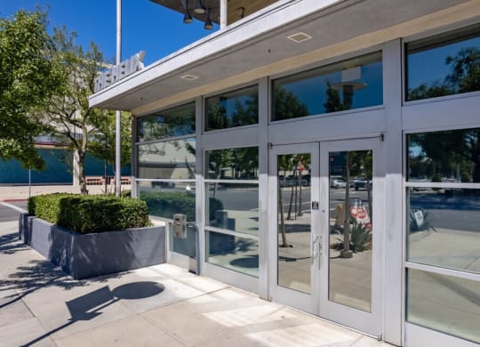 a large white building with glass doors and windows at Helix at University Village, Pomona, CA 91766