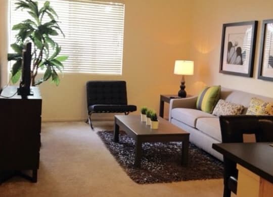 a living room with a couch and a chair at Helix at University Village, Pomona, CA
