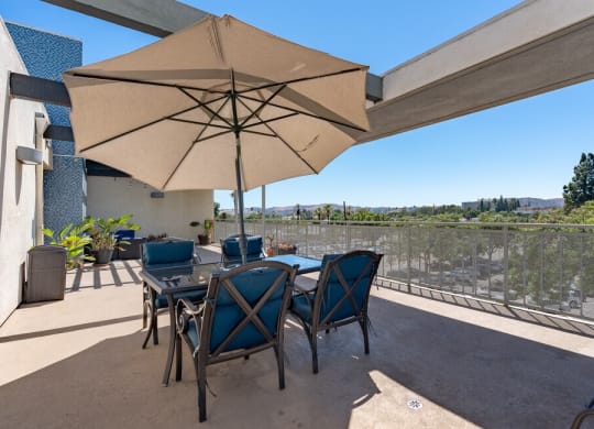 a patio with a table and chairs and an umbrella at Helix at University Village, California, 91766