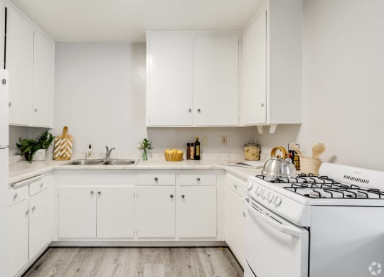 a white kitchen with white appliances and white cabinets at University Park, Azusa, CA