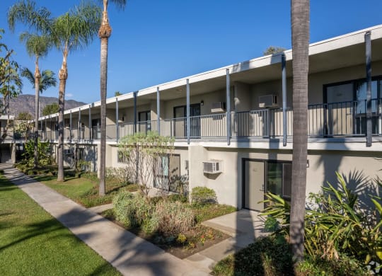 the courtyard of a condo building with palm trees at University Park, California