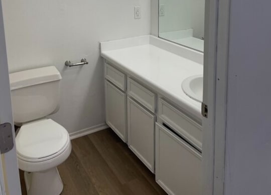 a bathroom with a toilet sink and mirror at Fiesta Apts, Lompoc, 93436