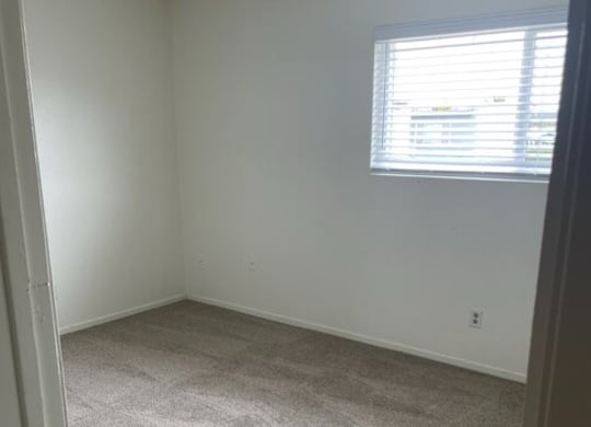 an empty room with a window and carpet at Fiesta Apts, Lompoc, CA