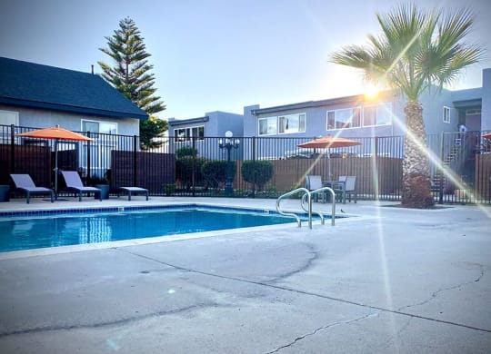 a swimming pool with a palm tree in front of a building at Fiesta Apts, Lompoc California