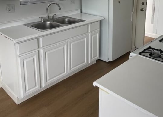 a kitchen with a sink a stove and a refrigerator  at Fiesta Apts, California