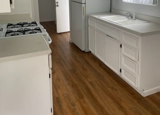a kitchen with a stove top oven next to a sink at Fiesta Apts, Lompoc, CA 93436