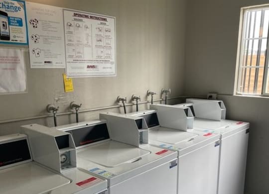 a row of white washing machines sitting next to each other at Fiesta Apts, Lompoc, 93436