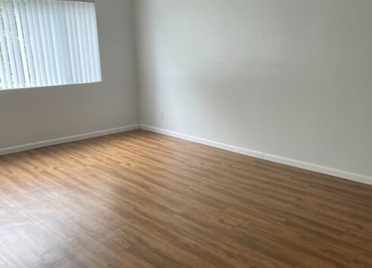 a bedroom with hardwood floors and a window at Fiesta Apts, Lompoc, CA