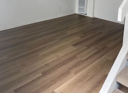 an empty living room with a staircase in the background at Fiesta Apts, Lompoc California