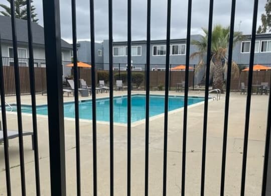 a swimming pool is seen through a fence at Fiesta Apts, California