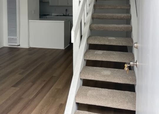 a staircase in a house with a kitchen in the backgroundat Fiesta Apts, Lompoc, 93436