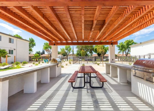 a patio with a picnic table and a grill at Sunnymead Apts Apartments, Moreno Valley, 92553