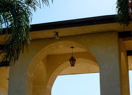 an archway with a light hanging from it with a blue sky in the background at Park Columbia Apts, Hemet, CA 92544
