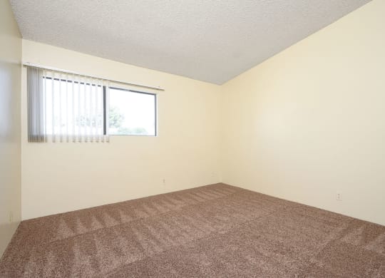 a bedroom with white walls and a window at Park Columbia Apts, Hemet, CA 92544