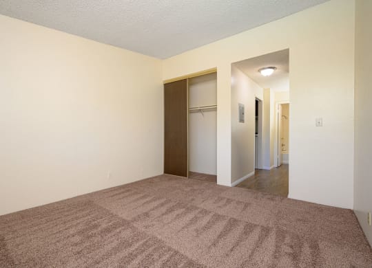 a bedroom with a carpeted floor and white walls at Park Columbia Apts, Hemet