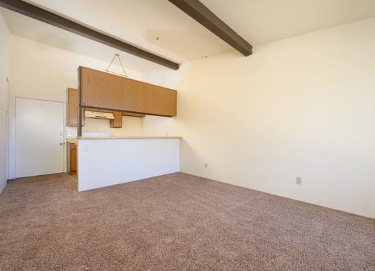 a kitchen and dining area in a room with white walls and carpet at Park Columbia Apts, Hemet, CA 92544
