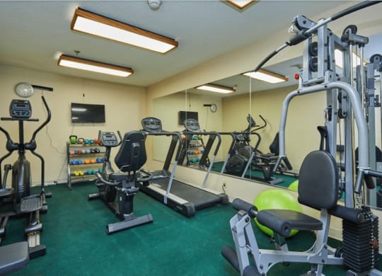 a gym with weights and other exercise equipment in a home gym at Huntington Terrace North Senior, Huntington Beach, CA 92648