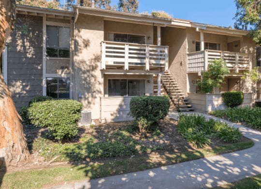 an apartment building with a sidewalk in front of it  at Alosta Place, Azusa, CA
