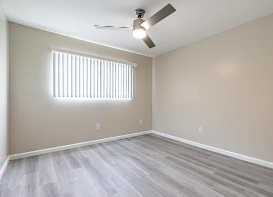 an empty living room with wood floors and a ceiling fan  at Colima Terrace Apts, Rowland Heights, CA 91748