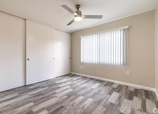 an empty living room with a ceiling fan and a window at Colima Terrace Apts, Rowland Heights, CA