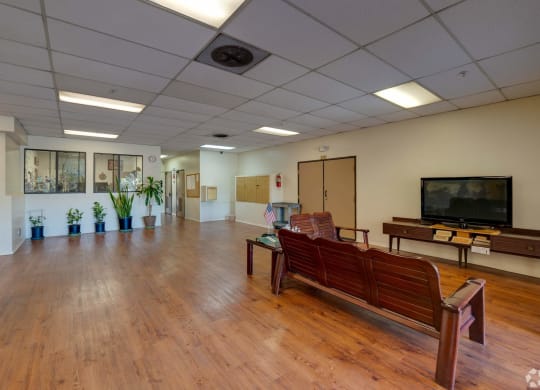 a large room with wooden floors and a television in the corner at Flamingo Garden Senior Apts, El Monte, 91732
