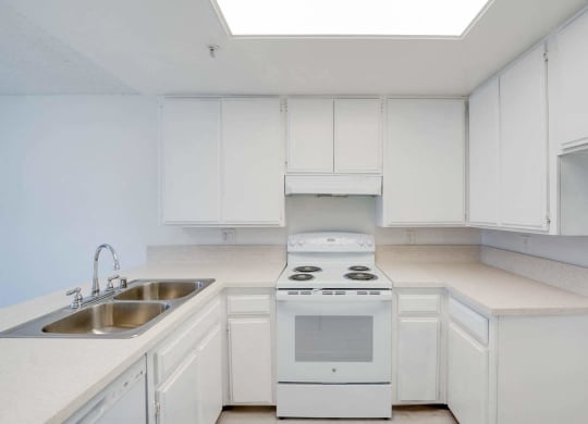 a kitchen with white cabinets and white appliances and a sink at Flamingo Garden Senior Apts, El Monte, CA 91732