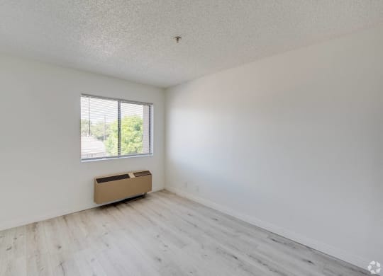 an empty room with white walls and a window at Huntington Terrace North Senior, California