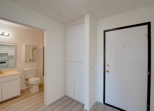 a bedroom with a door leading into a bathroom with a toilet and sink at Flamingo Garden Senior Apts, El Monte California
