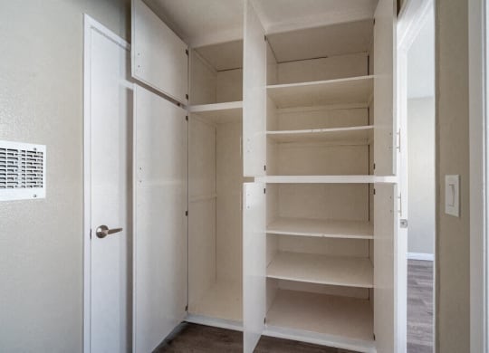 a closet with empty shelves and a door at North View Terrace, Montebello California