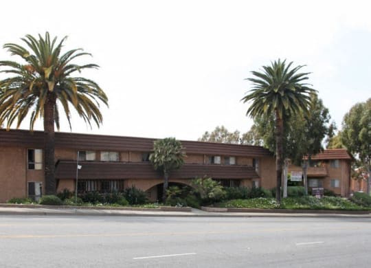a brown building with palm trees in front of it at North View Terrace, Montebello, 90640