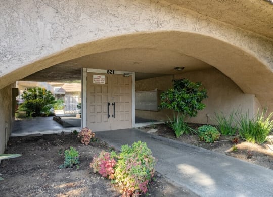 the front door of a building with a flower garden in front of it at North View Terrace, Montebello, CA 90640