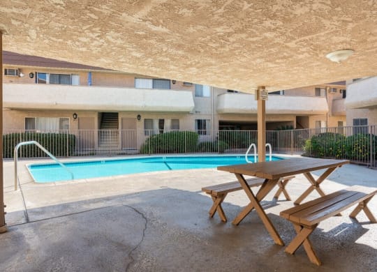 a pool with a picnic table in front of an apartment building at North View Terrace, California 