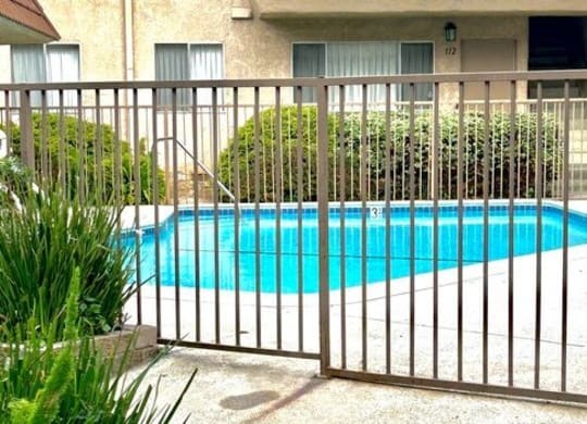 a swimming pool is behind a wrought iron fence at North View Terrace, Montebello, CA 90640