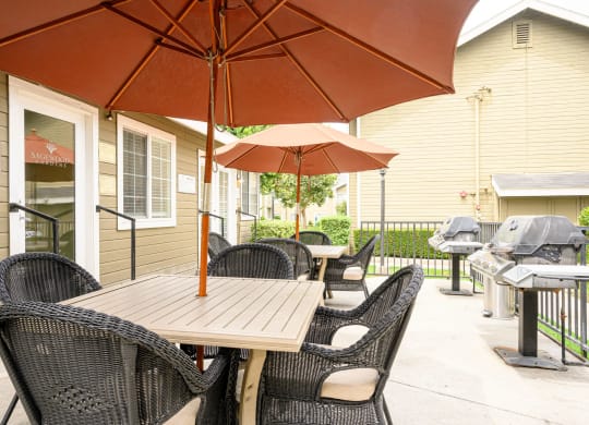 a patio with a table and chairs and an umbrella at Sagewood Gardens Senior Apartments, Hacienda Heights, CA 91745