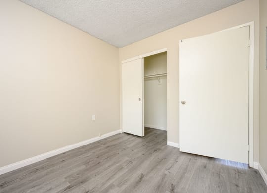 a bedroom with hardwood floors and beige walls at Sagewood Gardens Senior Apartments, Hacienda Heights, 91745