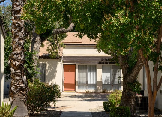 a building with a red door and trees in front of it at Villa Hemet, Hemet, 92543