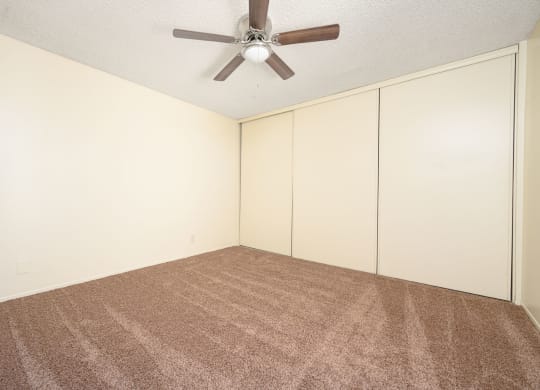 a bedroom with white walls and a ceiling fan at Villa Hemet, Hemet California
