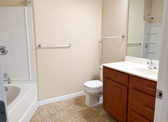 A white toilet sits in a bathroom next to a sink.