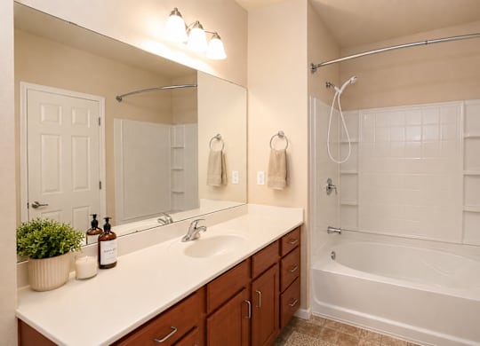 A bathroom with a white countertop and a white bathtub.