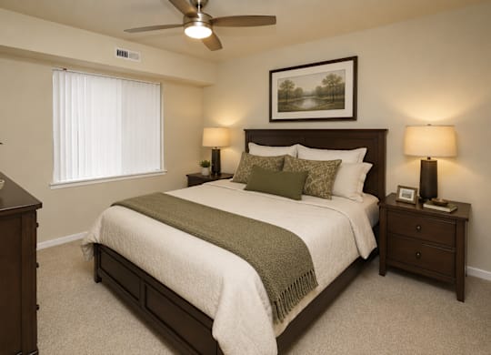 A bedroom with a bed, nightstands, and a ceiling fan.