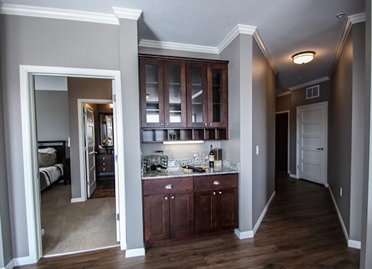 a kitchen with dark wood cabinets and granite countertops  at Victoria Park and V2 Apartments, St. Paul, Minnesota