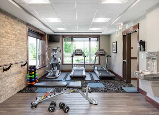 the fitness room filled with exercise equipment  at Victoria Park and V2 Apartments, Minnesota