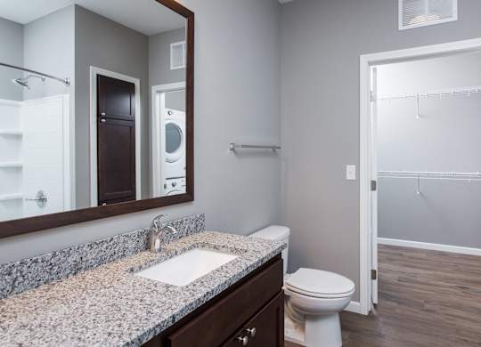 a bathroom with a toilet sink and mirror  at Victoria Park and V2 Apartments, Minnesota