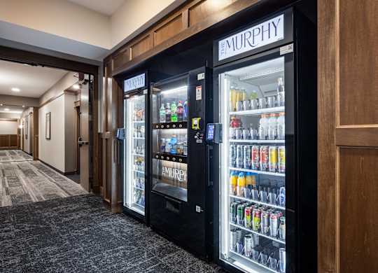 A row of vending machines are lined up against a wall.
