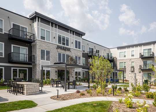 Apartment complex named Jamie with a patio and landscaping.