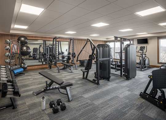 A well-equipped gym with a variety of exercise machines and weights.