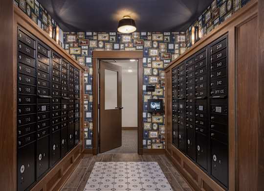 A hallway with a doorway leading to another room with a patterned floor.