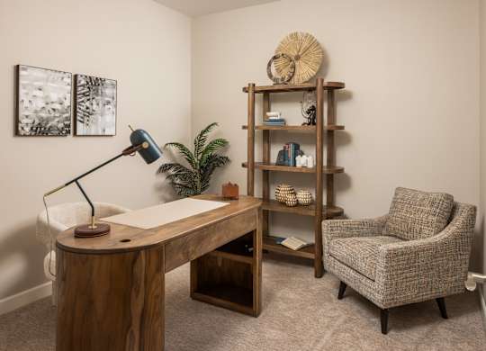 A room with a desk, chair, and bookshelf.