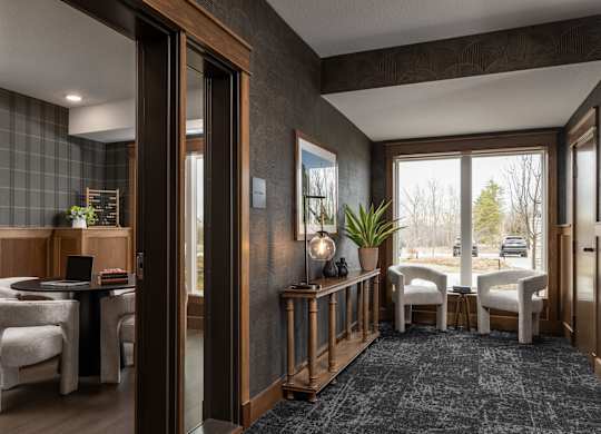 A modern living room with a dining area and a view of the outdoors.